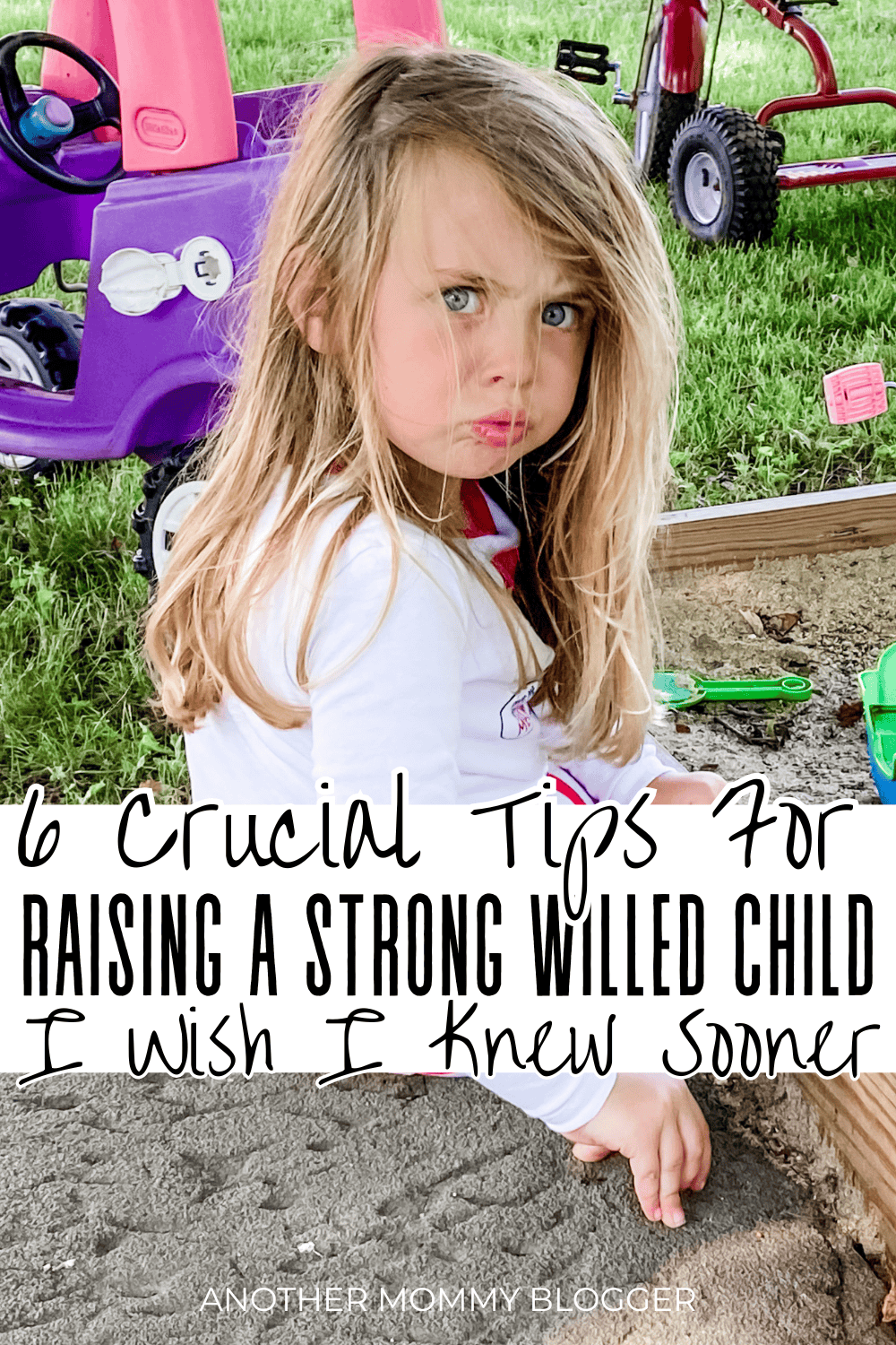 Toddler with a strong-willed personality frowning in the sandbox, showing frustration and fierce determination.