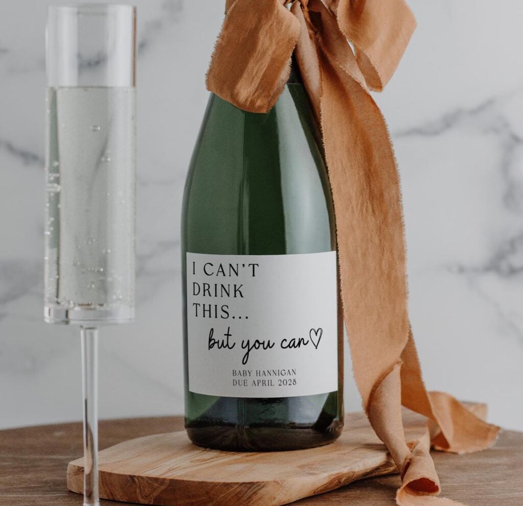 Pregnant announcement wine label that says “I can’t drink this, but you can”.