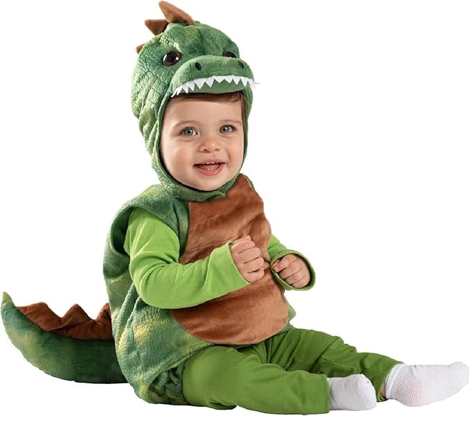 Smiling baby in a green dinosaur Halloween costume with a soft tail, brown belly, and dino hood featuring teeth and spikes — adorable option for a Jurassic Park family theme or toddler-friendly costume