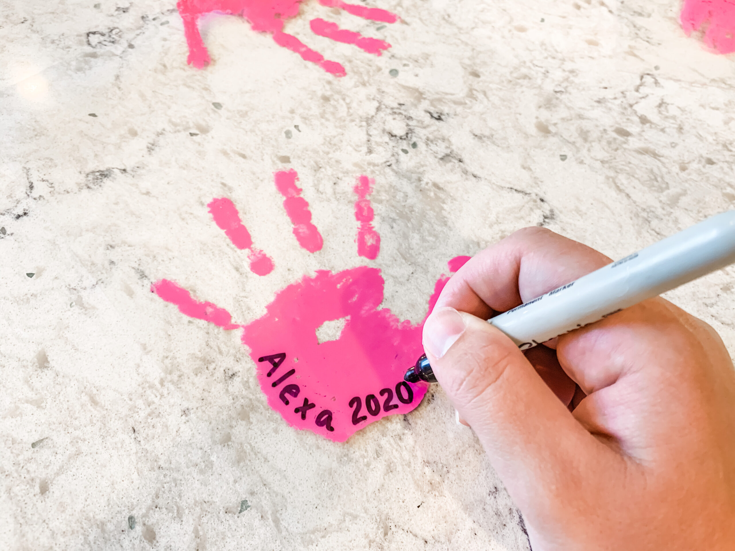 Adding name and year to DIY handprint keychain craft
