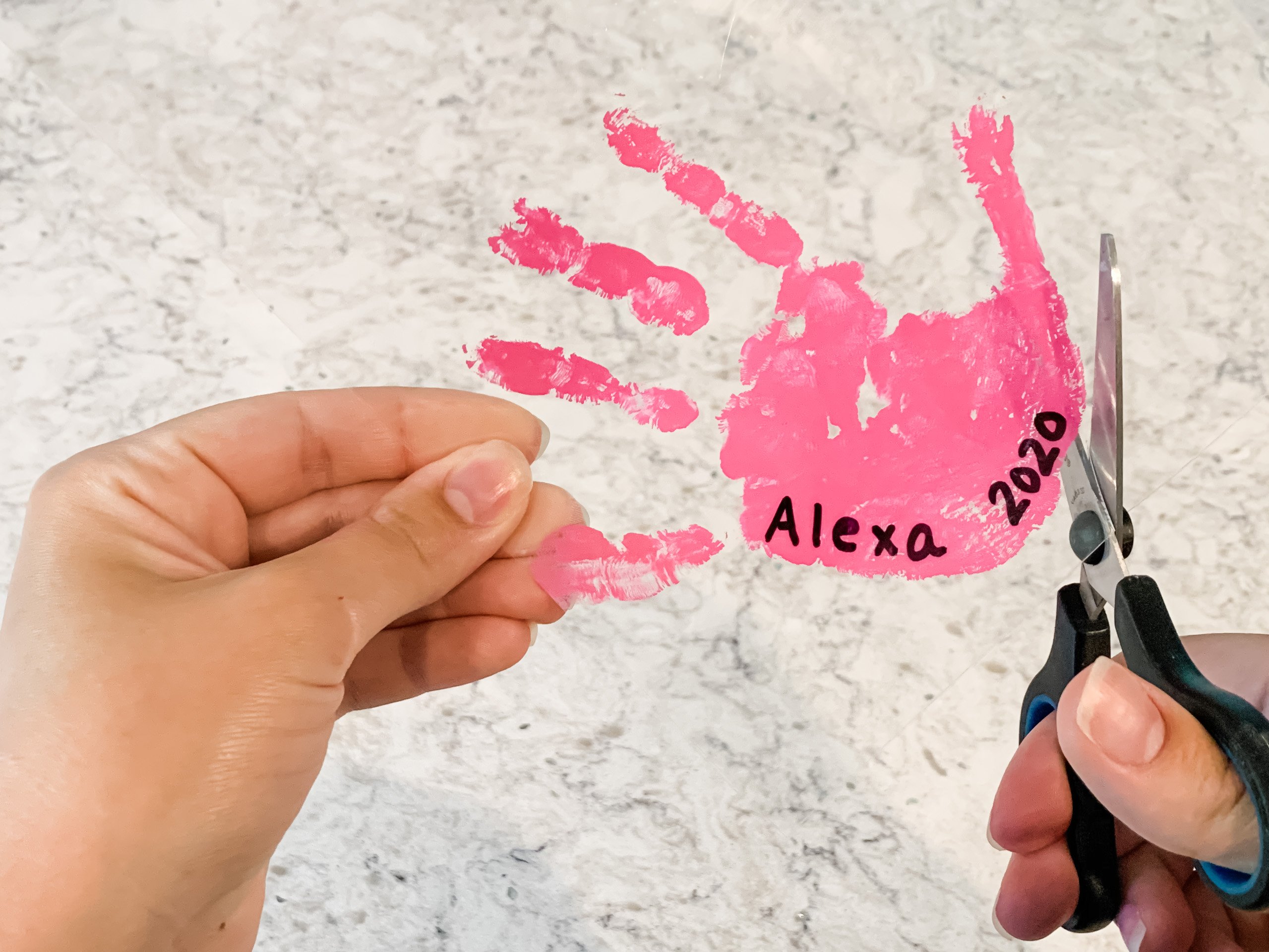 Cutting out handprint from shrink film for kid's keychain craft
