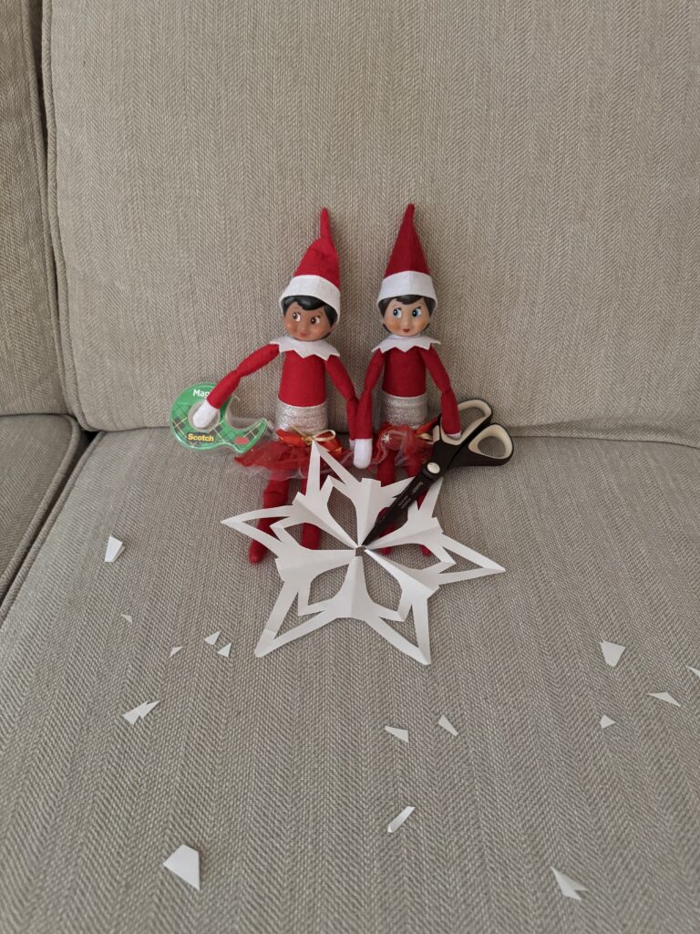 Elf on the shelf making paper snowflakes