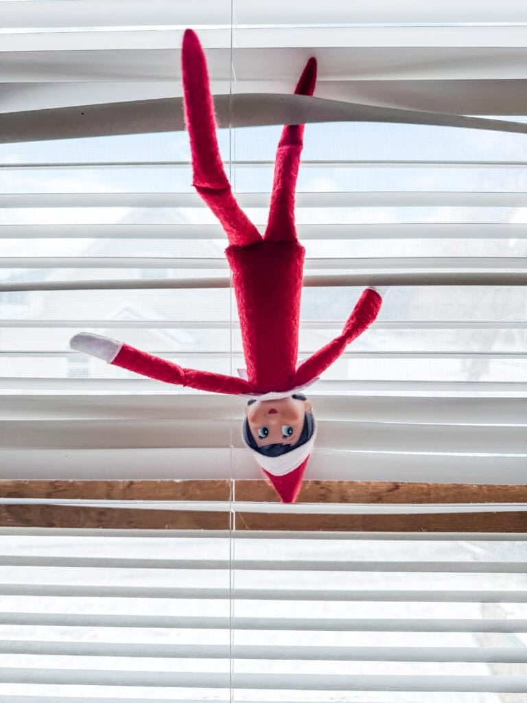 Elf on the shelf stuck in the blinds