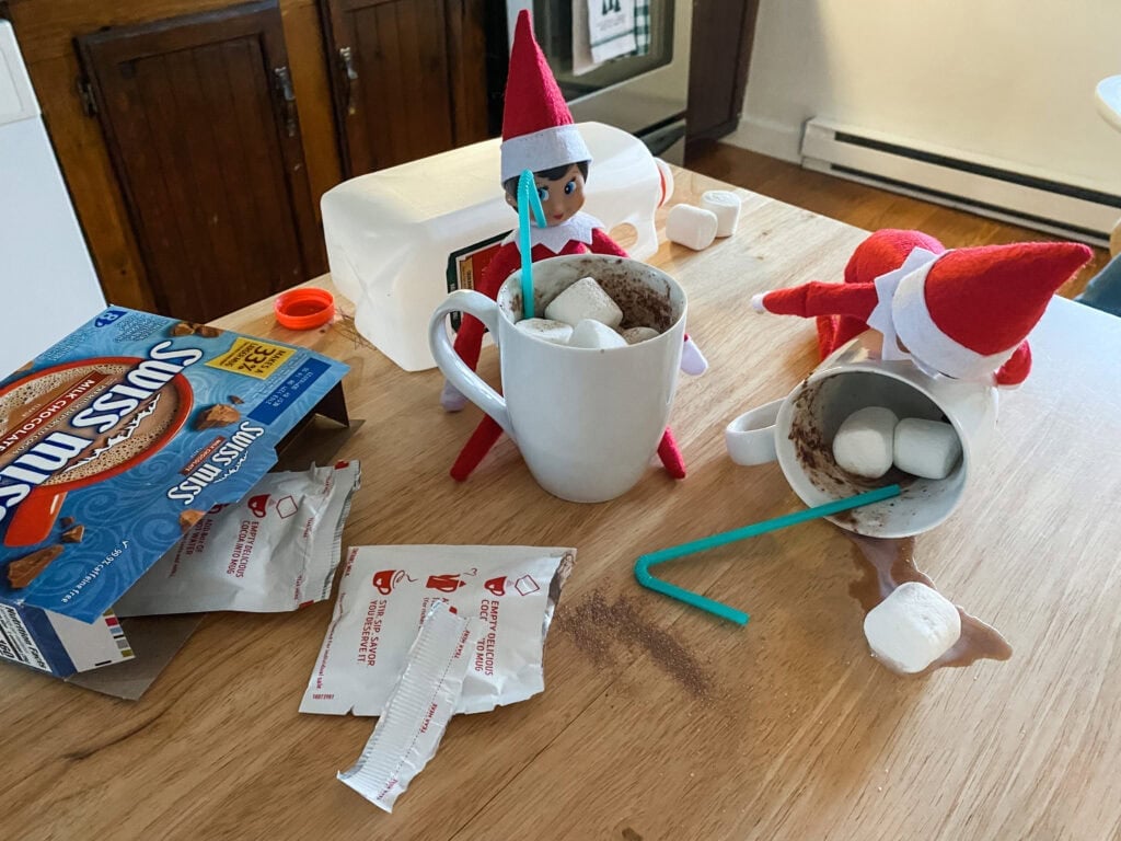 Messy elf on the shelf ideas shows scout elves with spilled hot chocolate.