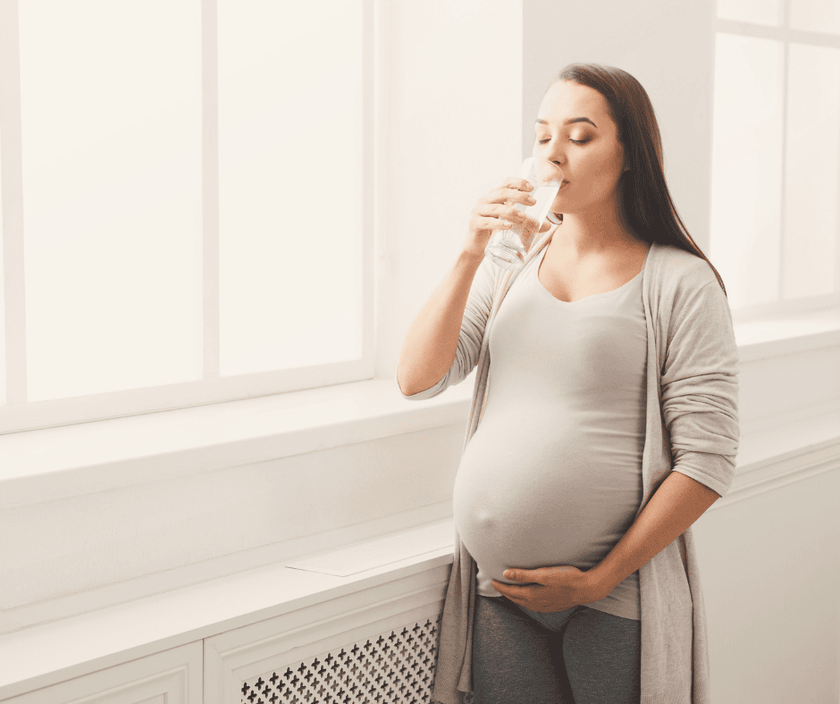 Pregnant woman drinking water.