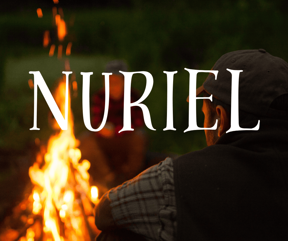 A man stares at a camp fire in front of him. Overlay text reads the boy name that means fire, “Nuriel”.