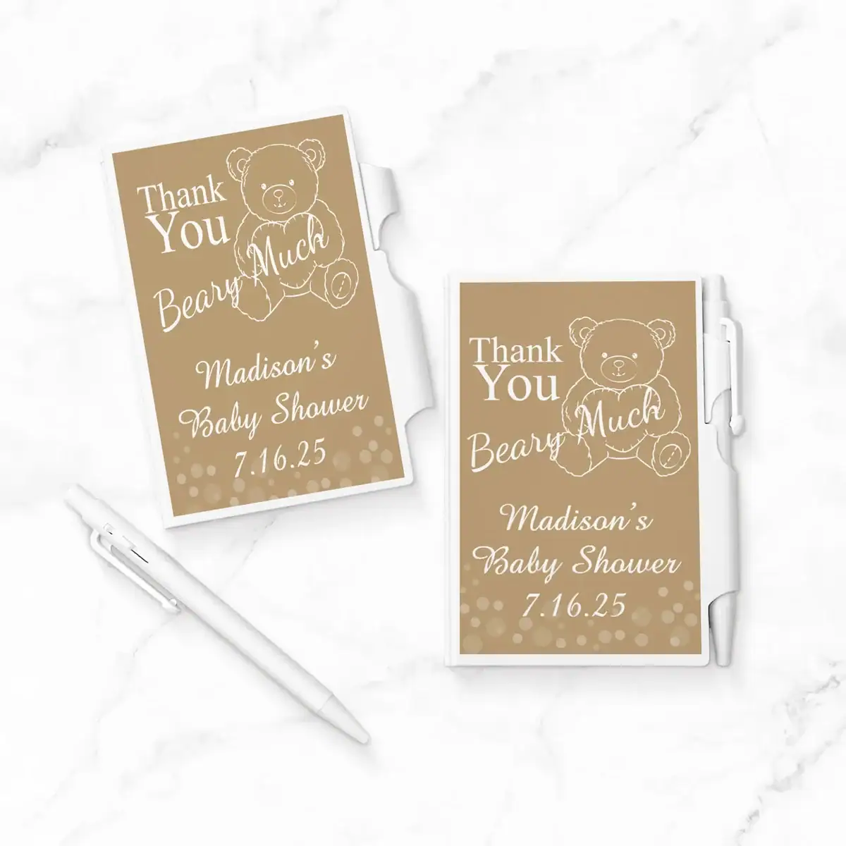 Personalized baby shower party favors featuring mini notepads with a teddy bear design and the message “Thank You Beary Much.” Customized with the guest of honor’s name and shower date, paired with white pens, perfect for a thoughtful and practical baby shower gift.