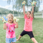 Two kids holding up soaked diy sponge water balloons during the summer.