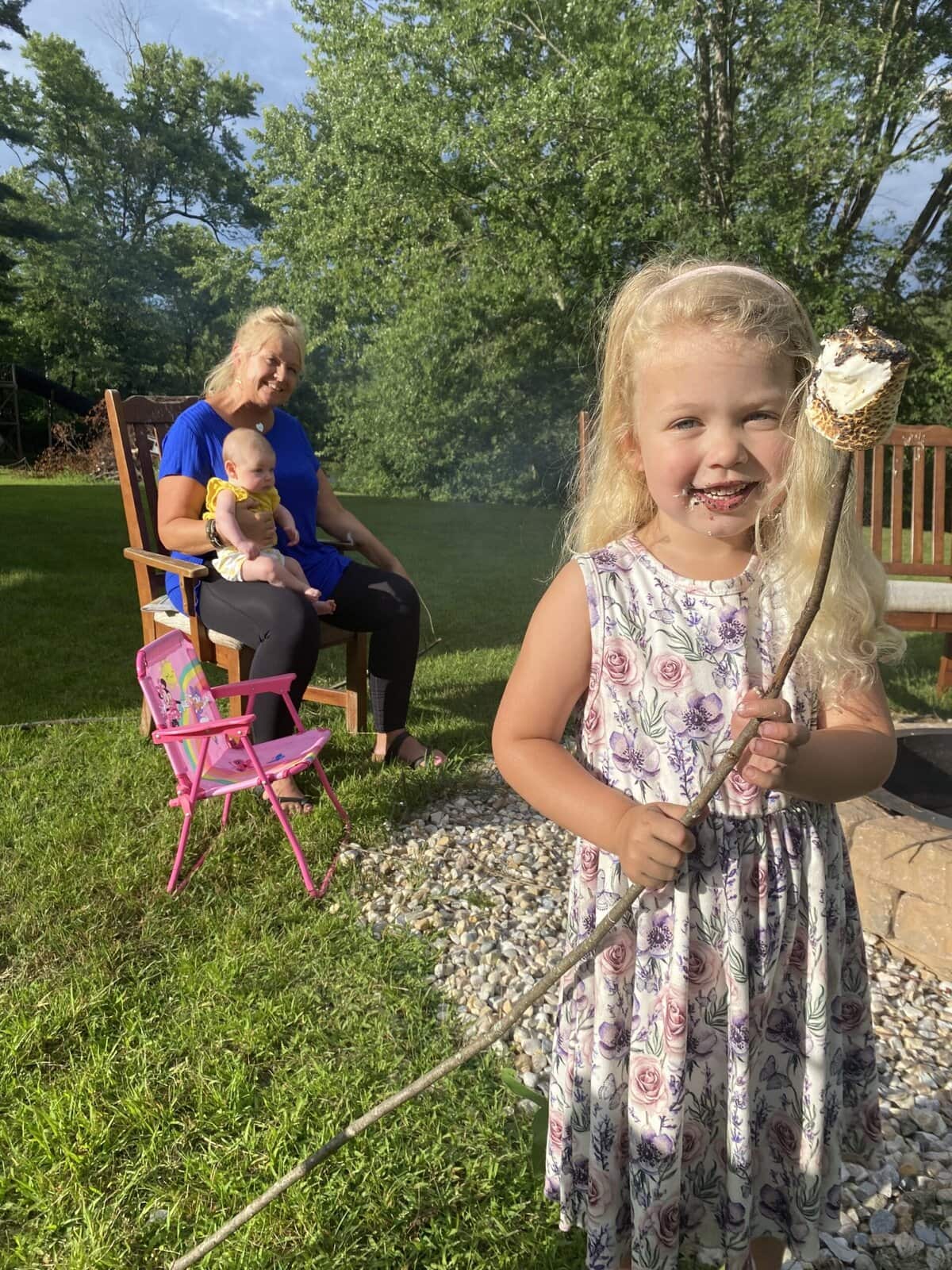Kids roasting marshmallows or holding gooey s’mores with chocolate and graham crackers
