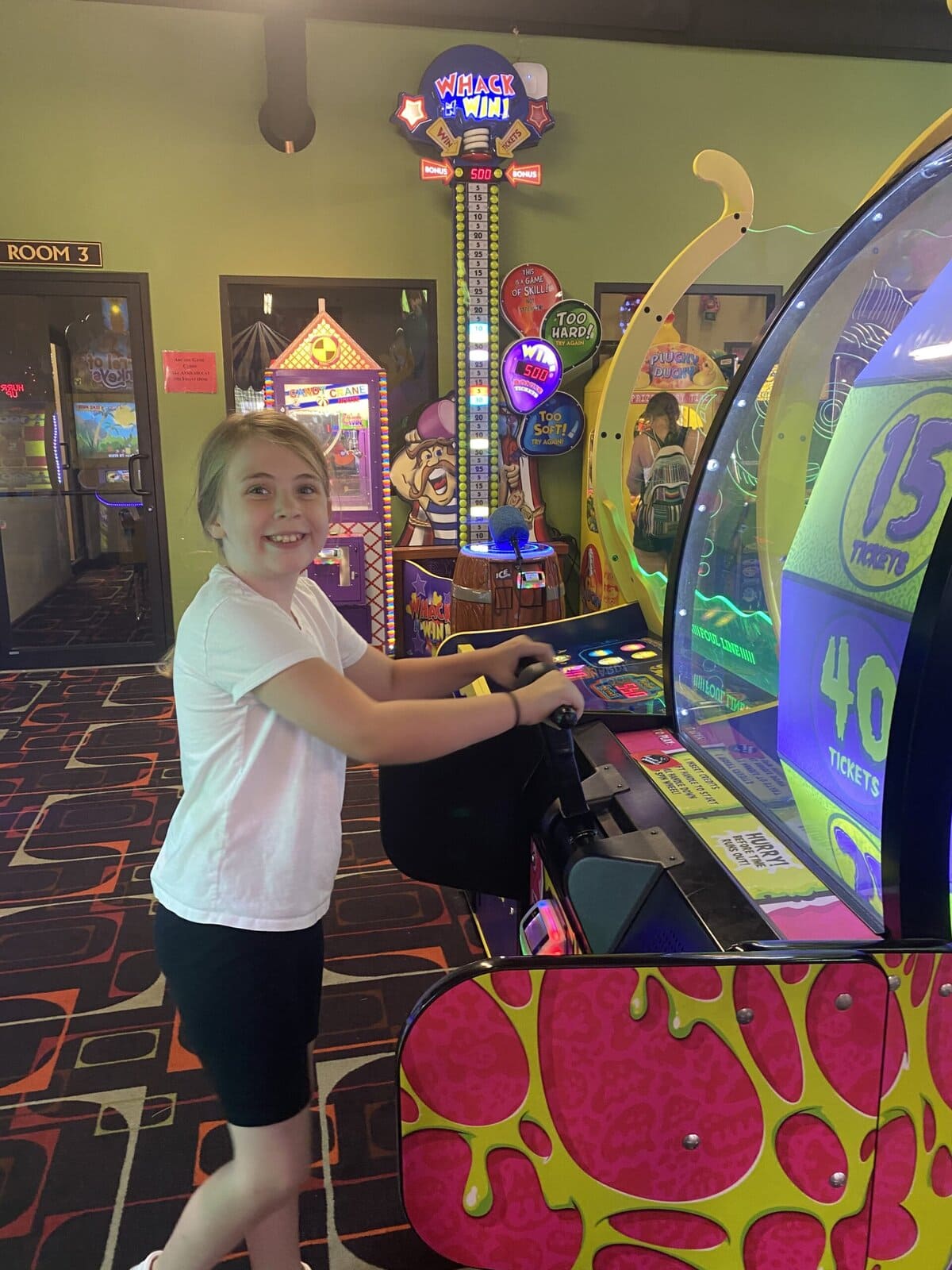 Child playing a colorful game in an arcade