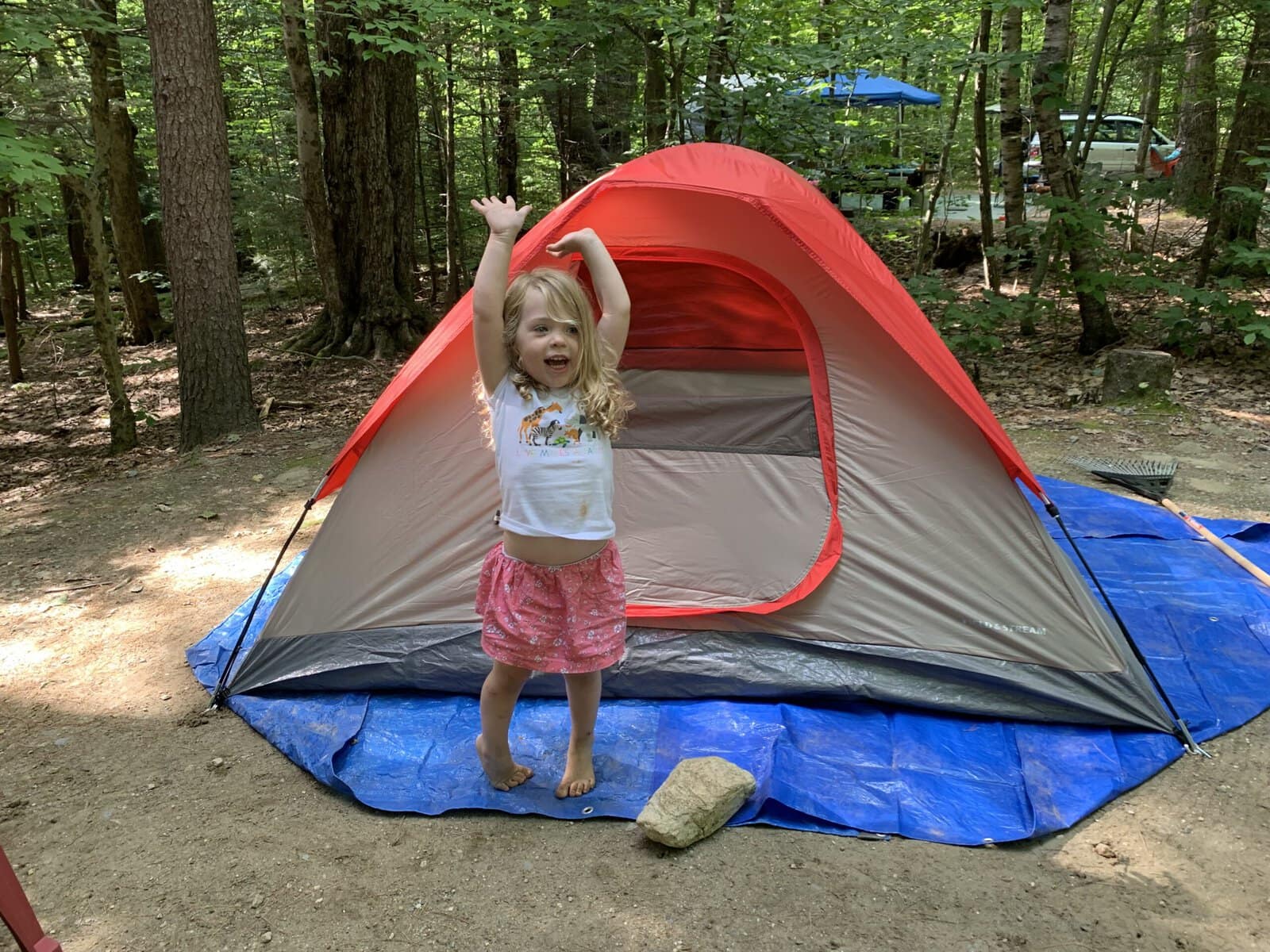 Kid standing in front of a tent during a backyard camping activity