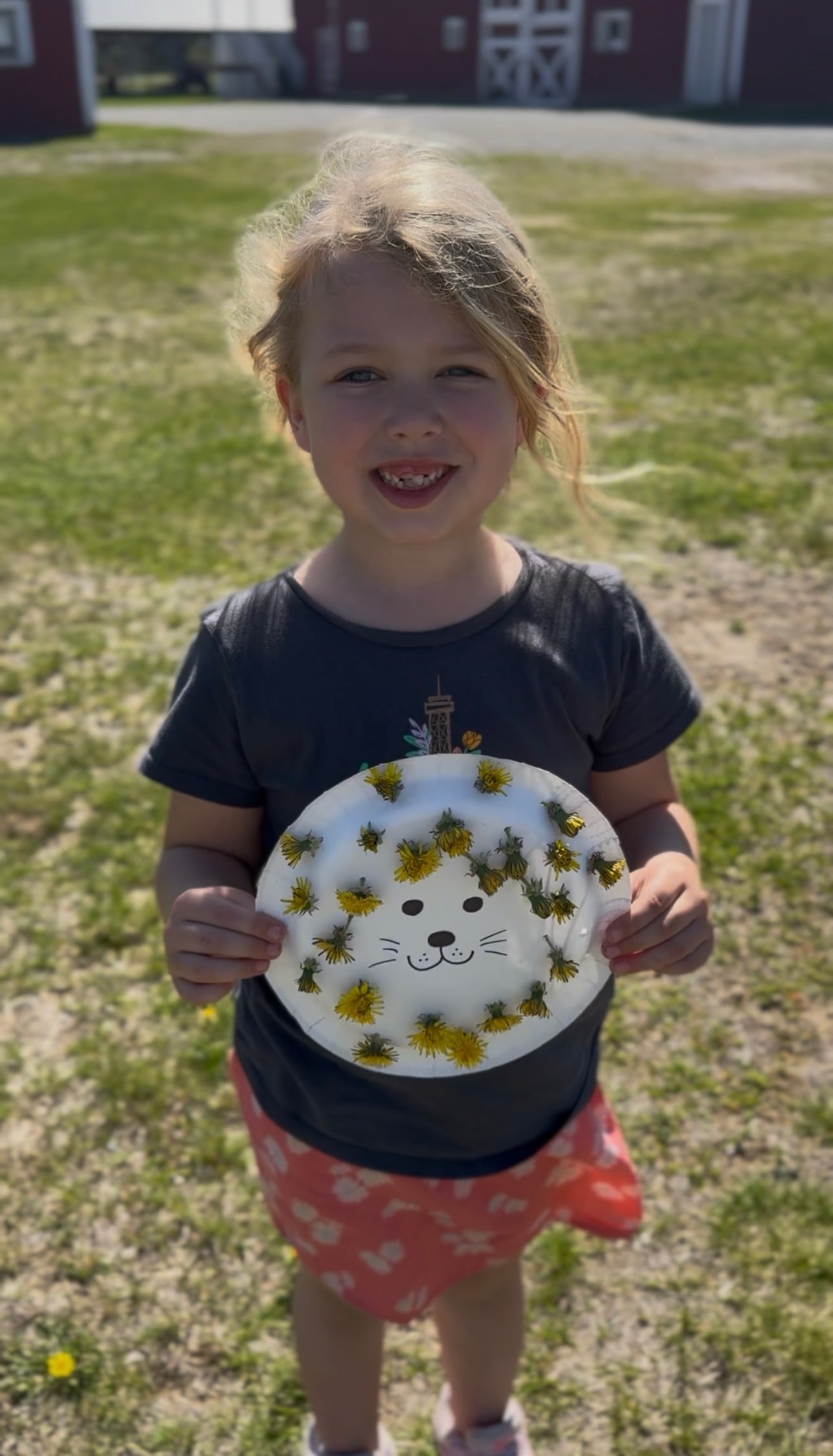 Girl holding dandelion paper plate activity.