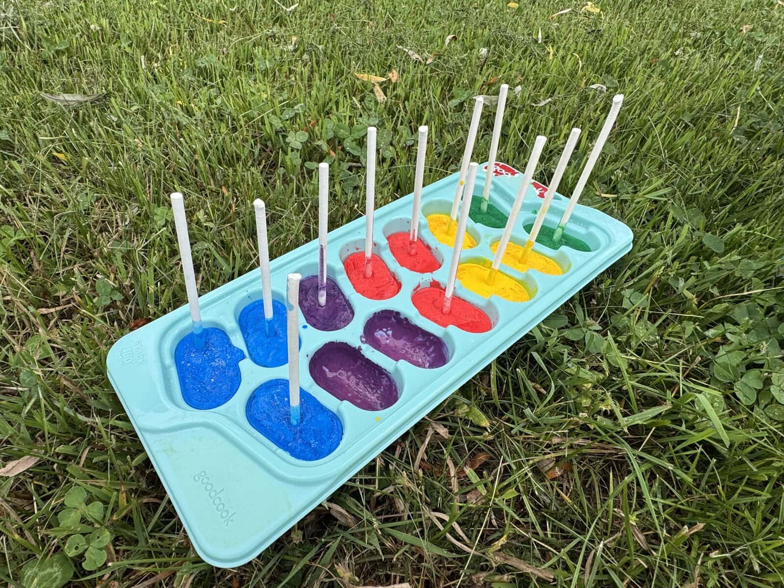 Frozen paint in an ice cube tray to be used for painting in a summer activity for kids.