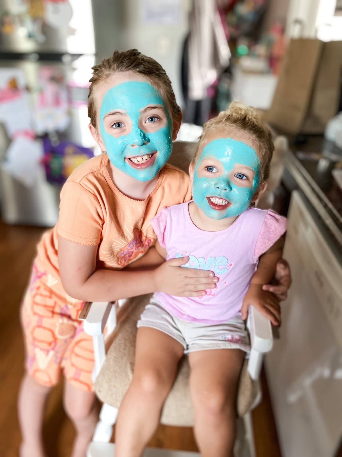 Girls with blue face masks smiling at their mom