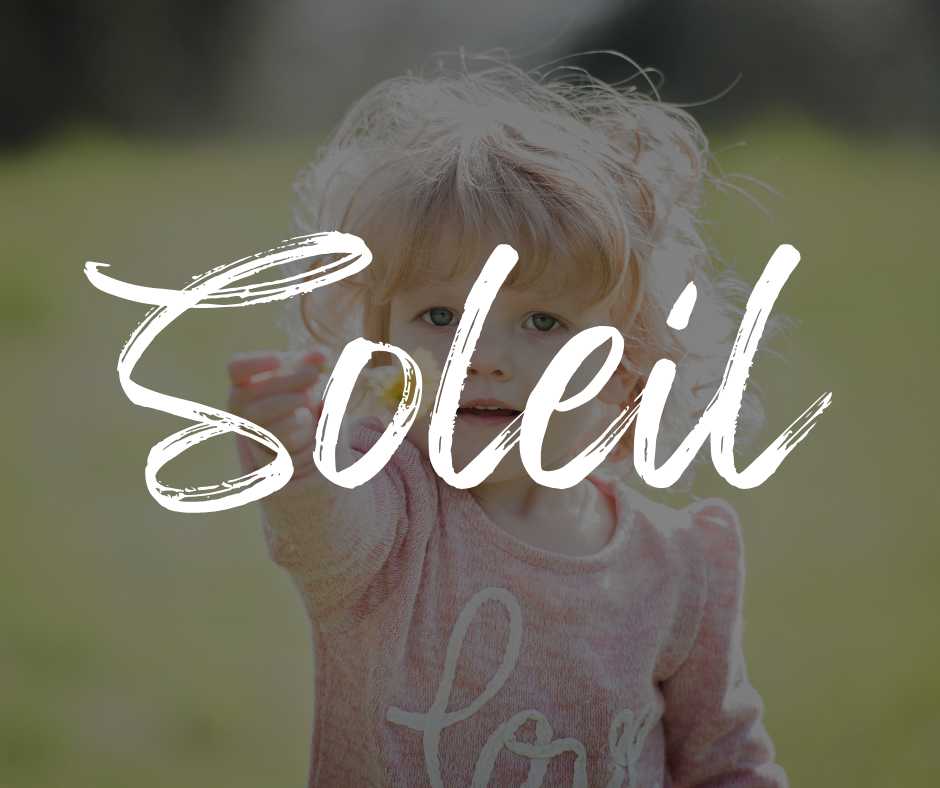 Blonde toddler girl in a pink sweater reaching out with a flower in hand, standing in a sunny field, with the name “Soleil” written in bold white script across the image.