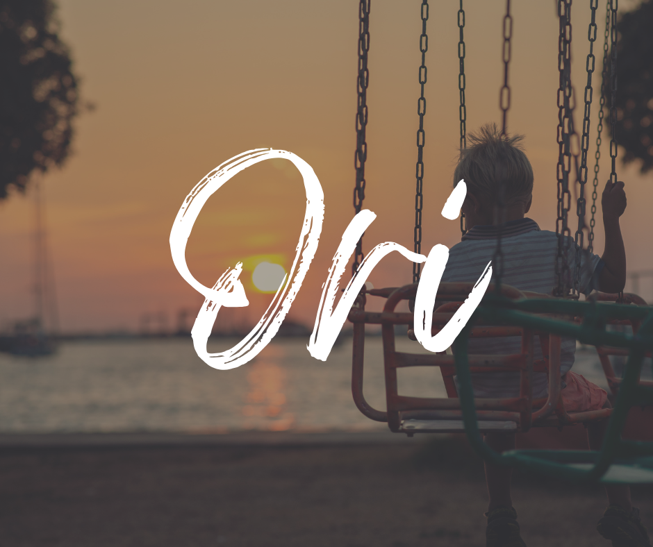 Child sitting on a swing at the beach during sunset, facing the water, with the name “Ori” written in large white script across the image.