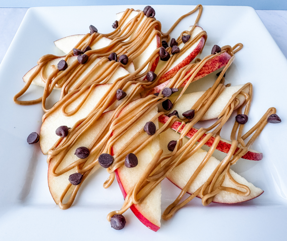 Apple nachos made with sliced apples, drizzled peanut butter, and mini chocolate chips. A fun and healthy snack idea for kids.