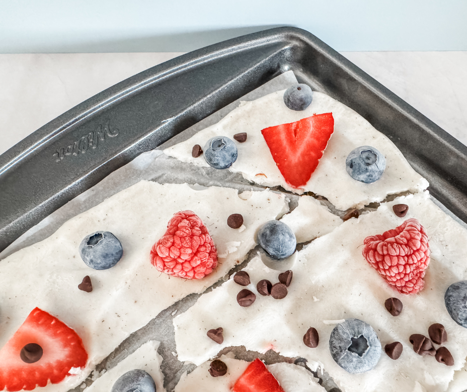 Frozen yogurt bark topped with strawberries, raspberries, blueberries, and mini chocolate chips