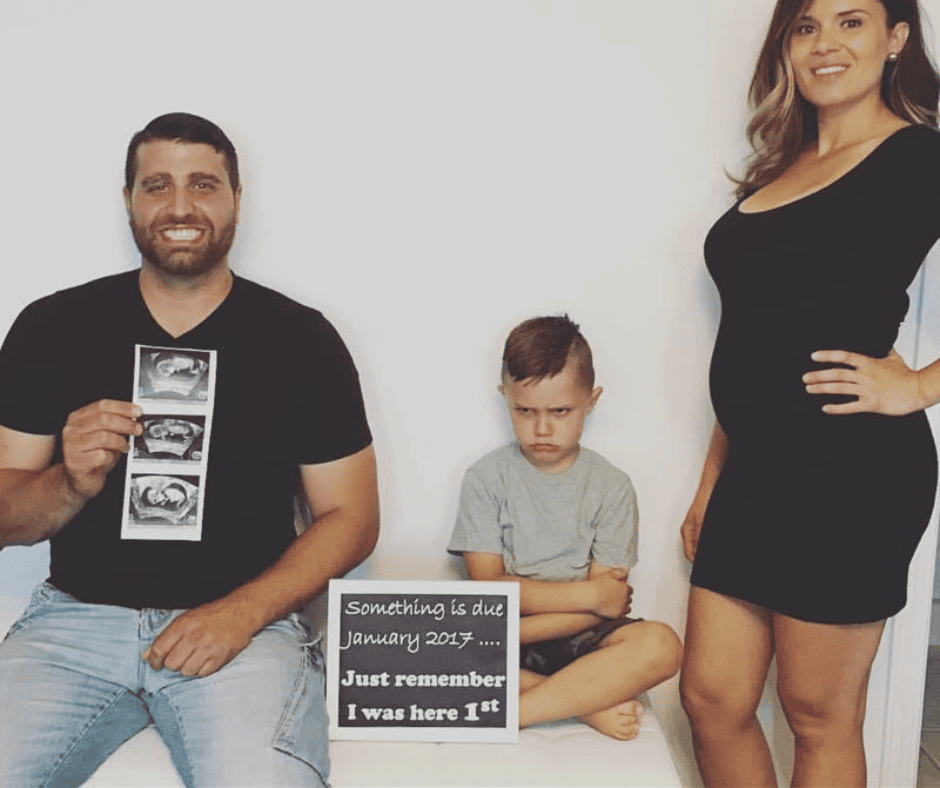 Funny pregnancy announcement idea photo with parents announcing the pregnancy and their child making a funny pout face.