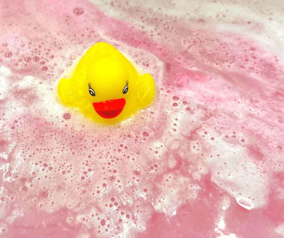 Duck floats in a pool of pink water for a gender reveal party idea.