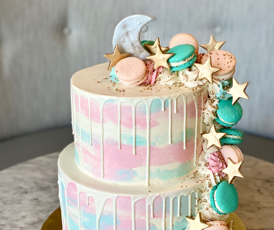 Moon and star themed gender reveal cake with white chocolate drizzle and macarons.