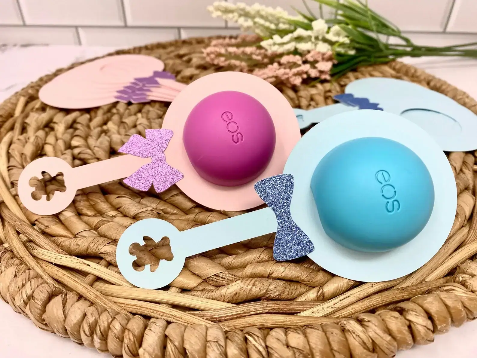 Baby shower party favors that are Eos chap sticks inside of a paper rattle.