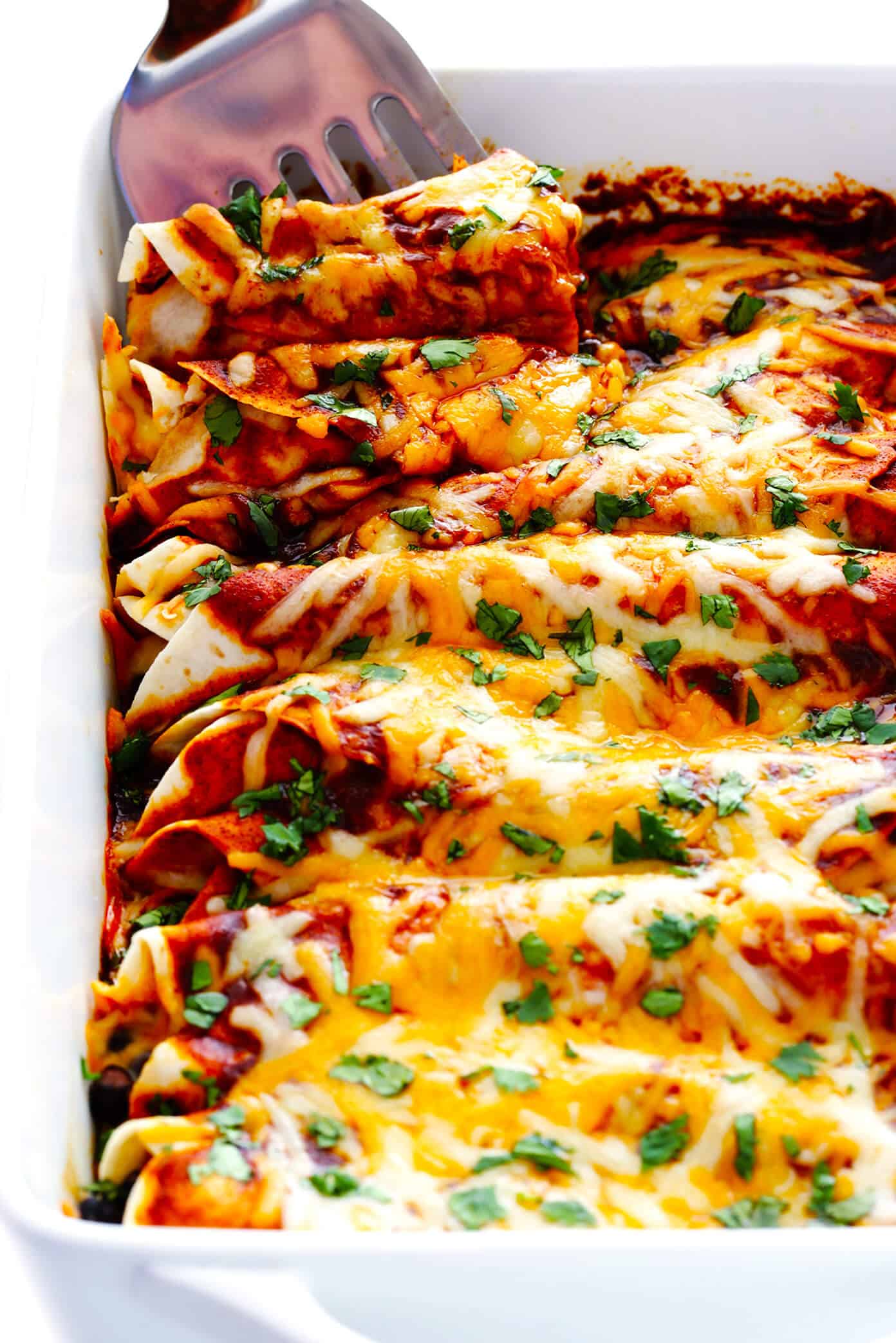 Chicken enchiladas with melted cheese and red sauce baked in casserole dish