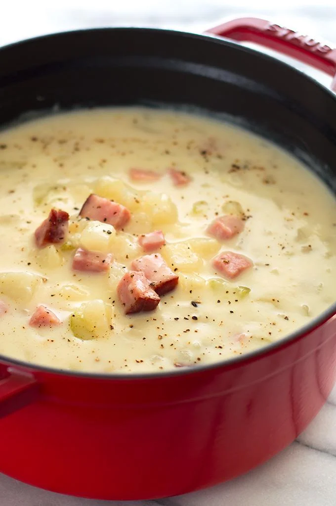 Creamy ham and potato soup with diced ham and potatoes in pot