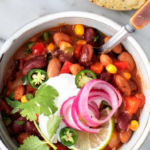 Vegetarian chili with beans corn and peppers topped with sour cream