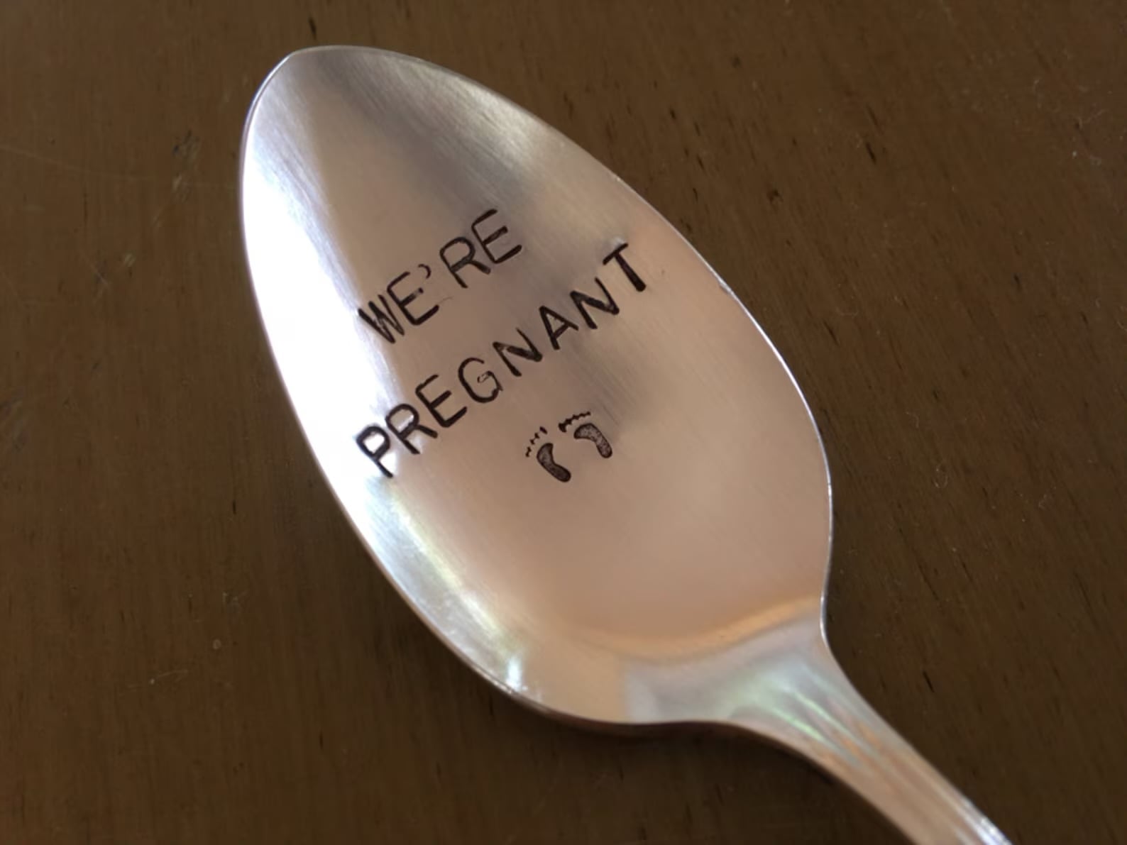 Pregnancy announcement spoon with the message we’re pregnant on it