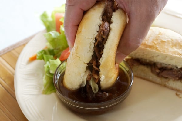 Slow cooker French dip sandwich with tender shredded beef served on a toasted roll with au jus dipping sauce.