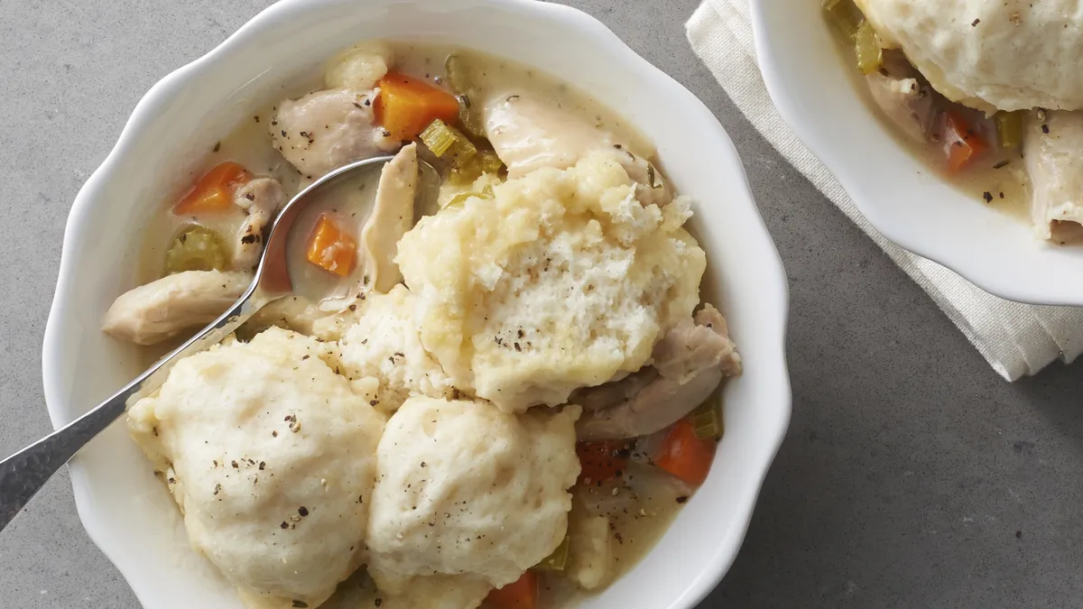  Crockpot chicken and dumplings with carrots, celery, and creamy broth topped with fluffy dumplings as a freezer meal for new moms.