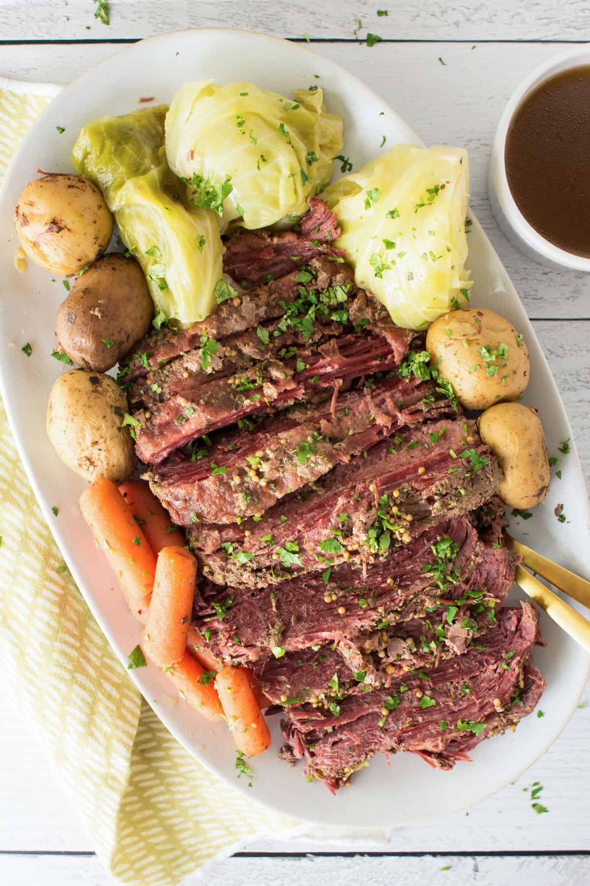 Slow cooker corned beef and cabbage served with potatoes, carrots, and cabbage wedges on a platter.