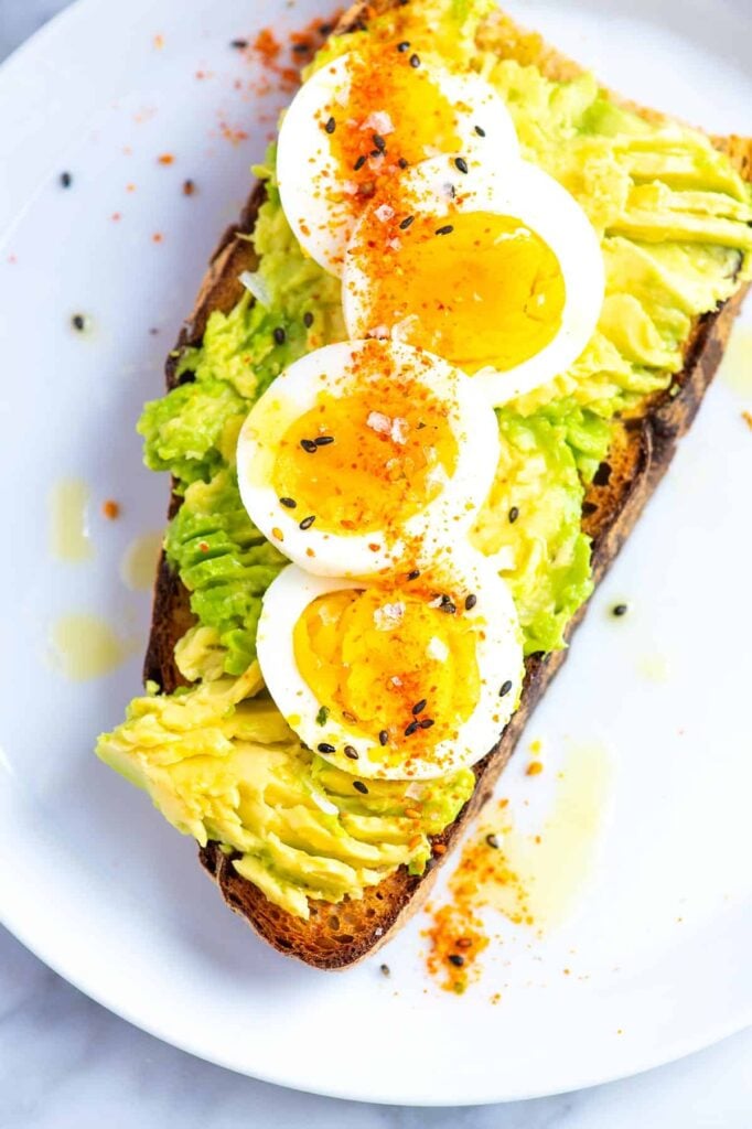 Easy gestational diabetes breakfast consisting of whole grain avocado toast topped with soft-boiled eggs and seasonings.