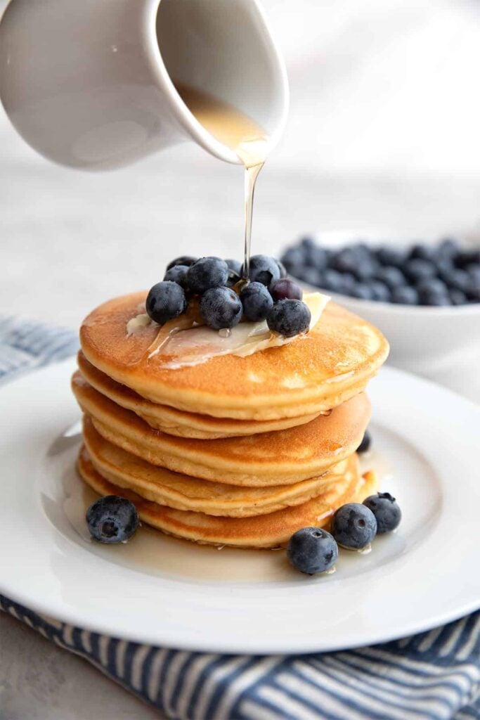 Easy gestational diabetes breakfast consisting of fluffy almond flour pancakes topped with butter, fresh blueberries, and sugar-free syrup.
