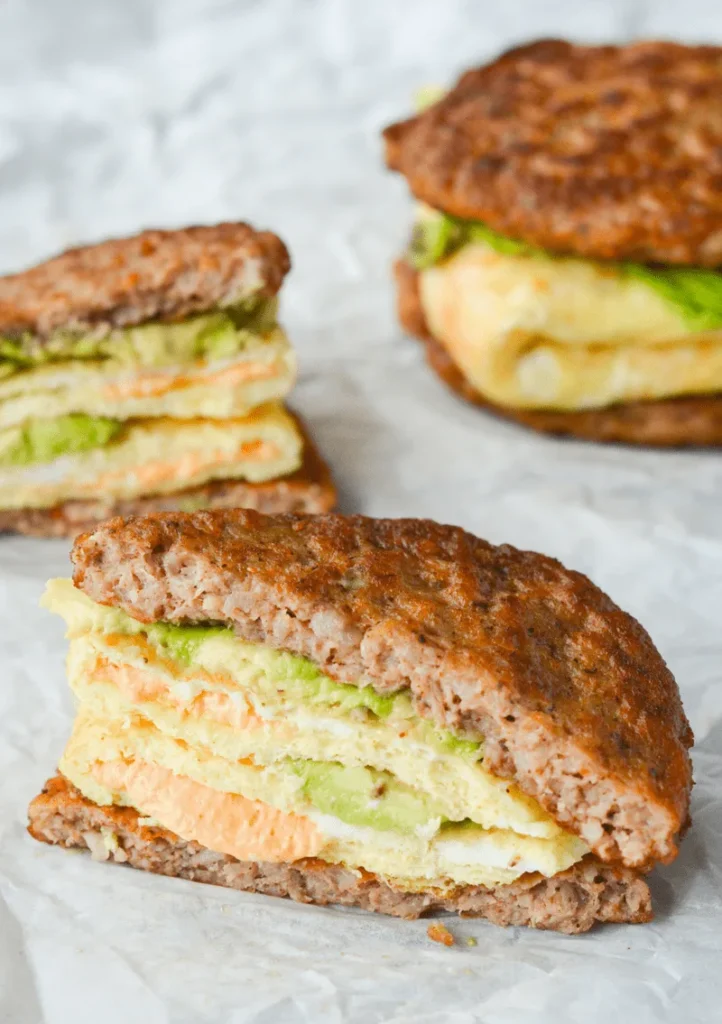 Easy gestational diabetes breakfast consisting of a keto breakfast sandwich with sausage patties, eggs, cheese, and avocado.